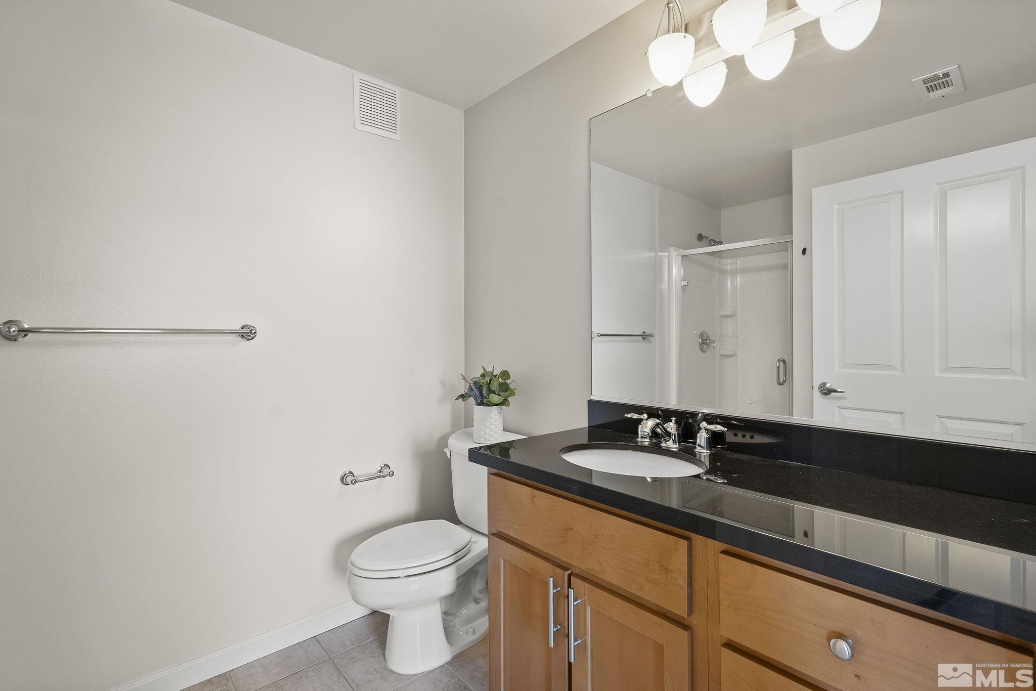 1450 Idlewild Drive, Unit 933 Reno, NV 89509 - Photo 16 of 32 a bathroom with a granite countertop sink and a toilet