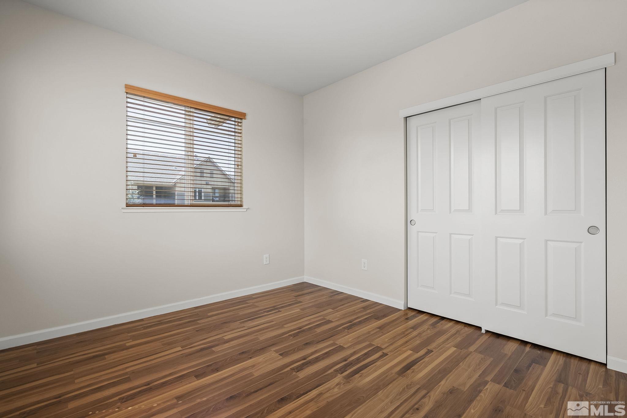 1450 Idlewild Drive, Unit 933 Reno, NV 89509 - Photo 18 of 32 a view of an empty room with wooden floor and a window