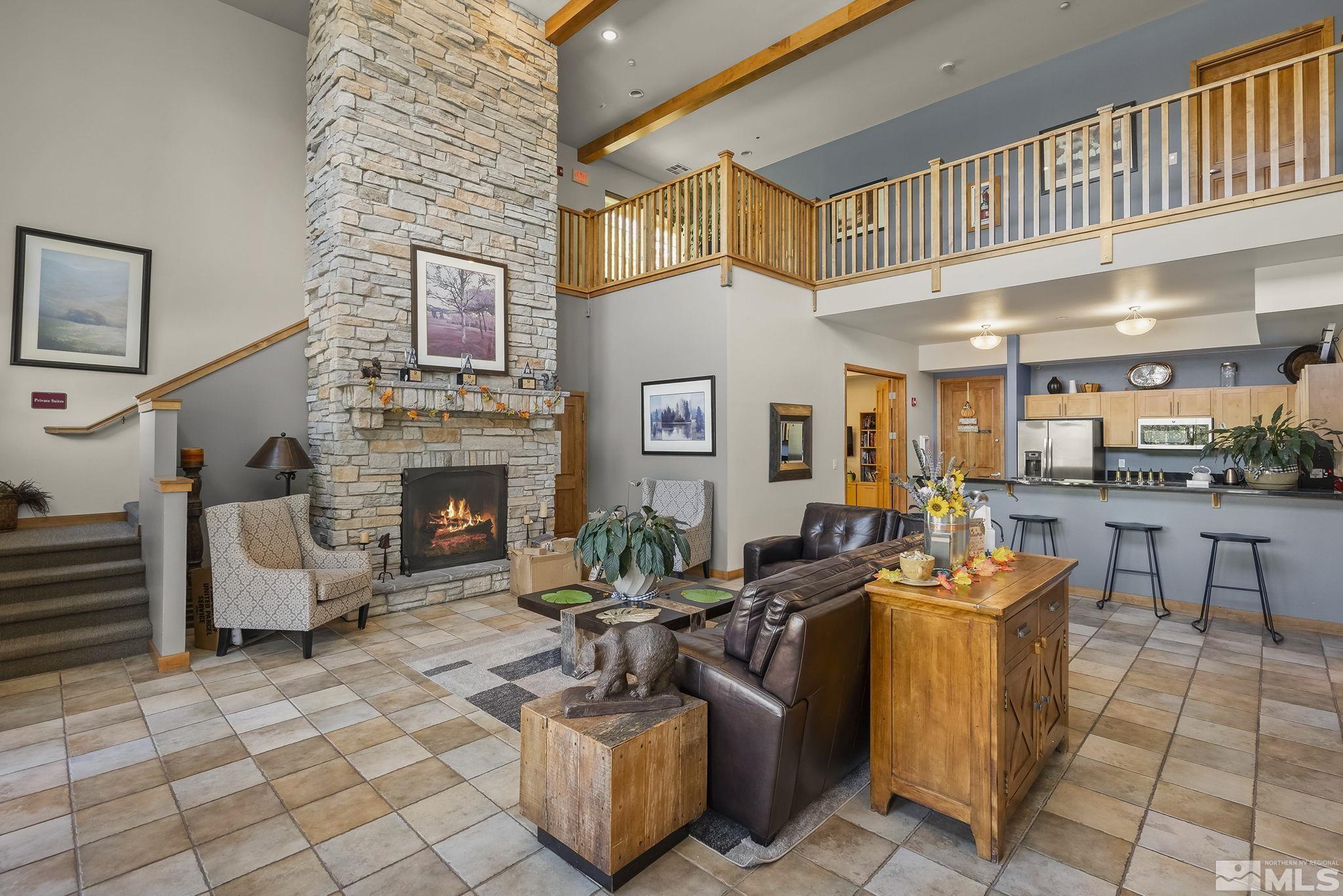 1450 Idlewild Drive, Unit 933 Reno, NV 89509 - Photo 24 of 32 a living room with furniture a fireplace and a table