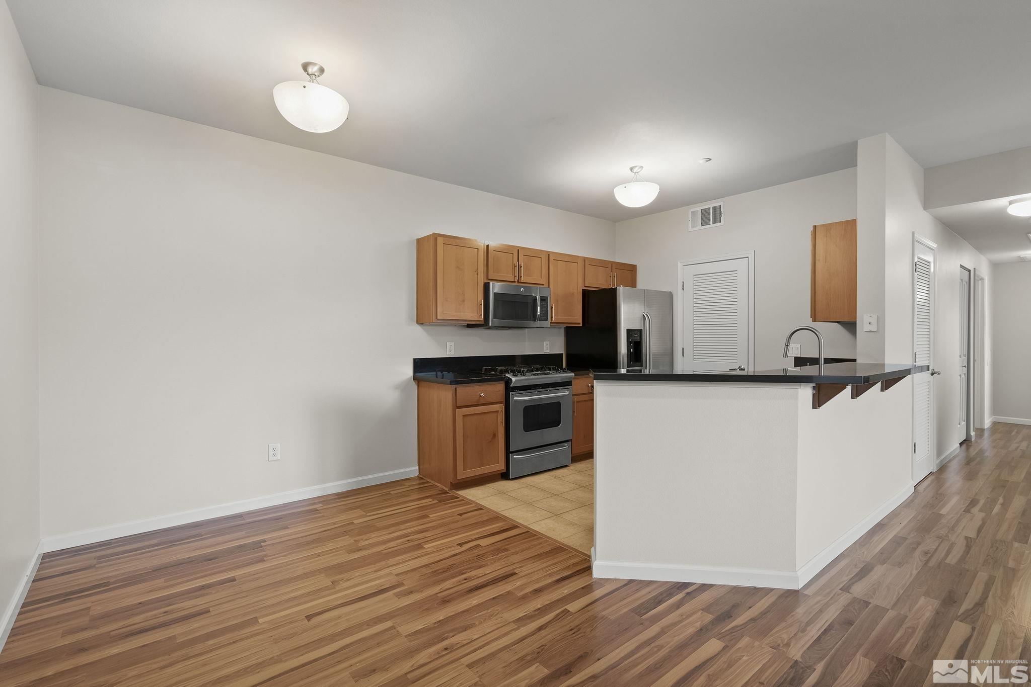 1450 Idlewild Drive, Unit 933 Reno, NV 89509 - Photo 3 of 32 a kitchen with stainless steel appliances a refrigerator and a stove top oven