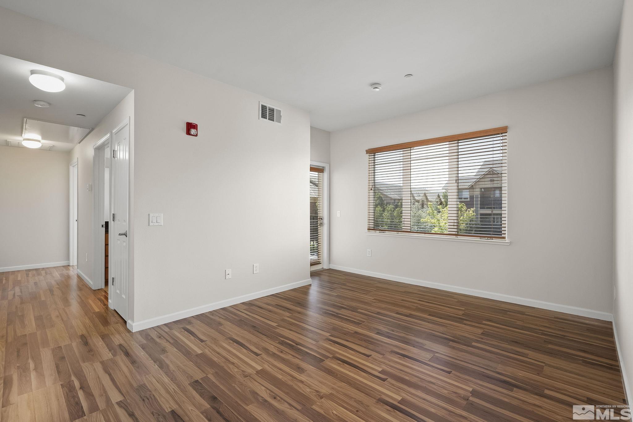 1450 Idlewild Drive, Unit 933 Reno, NV 89509 - Photo 6 of 32 a view of an empty room with wooden floor and a window