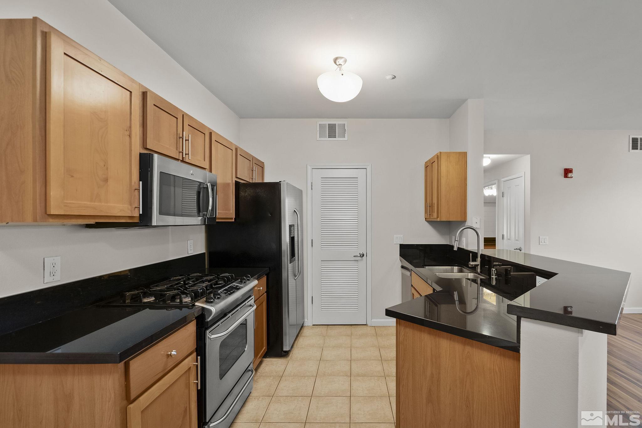 1450 Idlewild Drive, Unit 933 Reno, NV 89509 - Photo 8 of 32 a kitchen with a sink stove and refrigerator