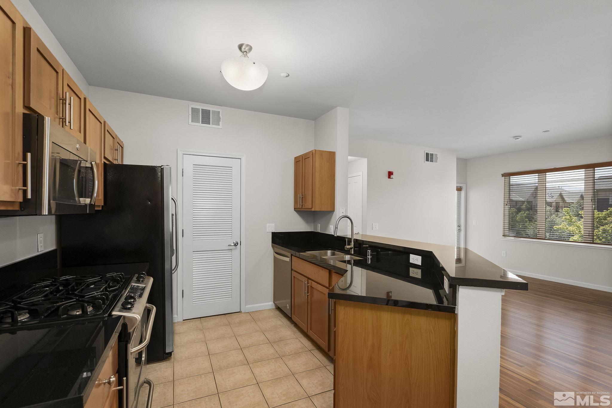 1450 Idlewild Drive, Unit 933 Reno, NV 89509 - Photo 9 of 32 a kitchen with granite countertop a stove and a refrigerator