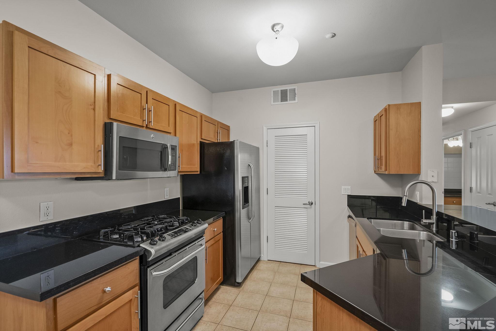 1450 Idlewild Drive, Unit 933 Reno, NV 89509 - Photo 10 of 32 a kitchen with stainless steel appliances granite countertop a sink stove and refrigerator