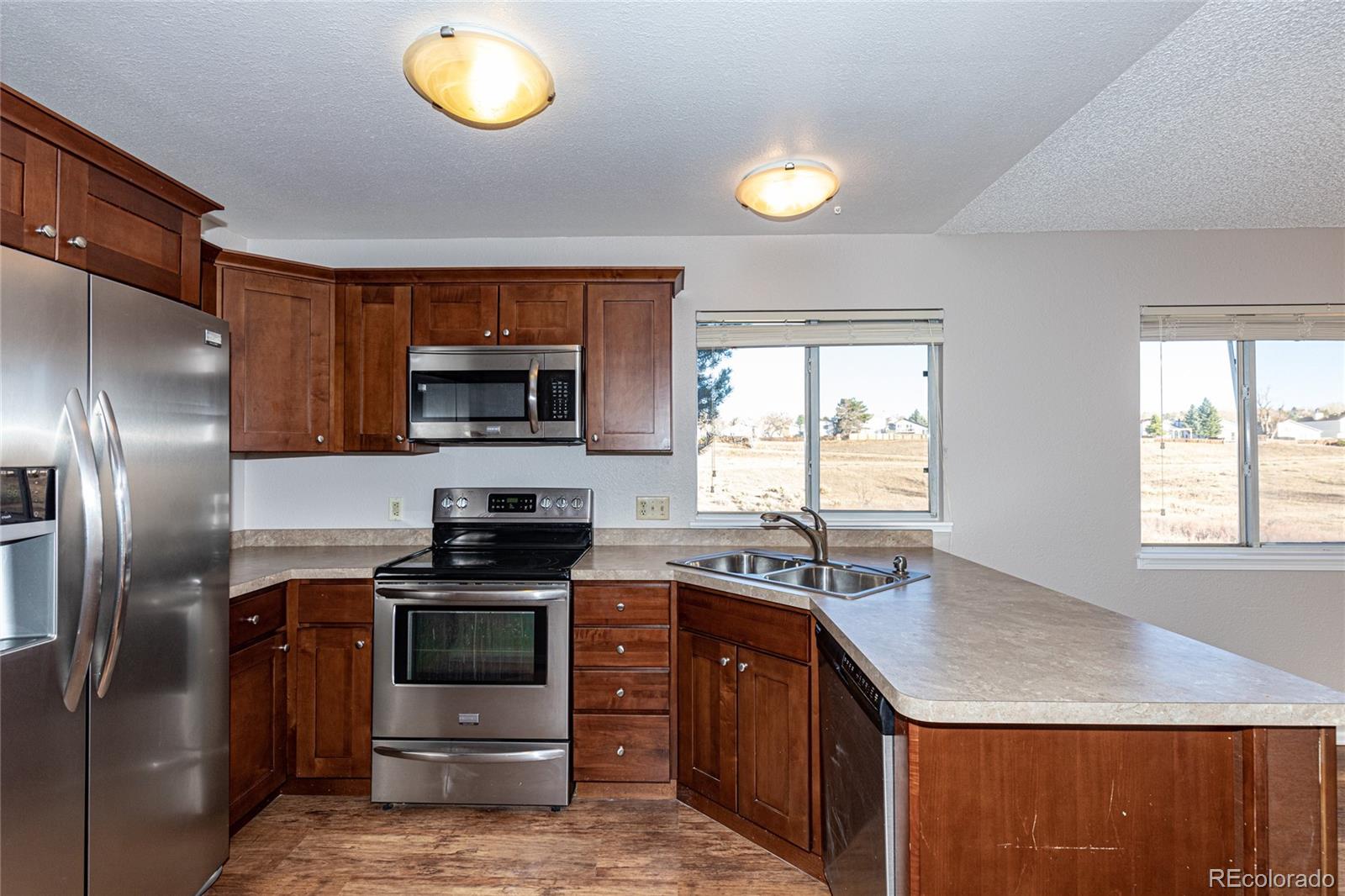 9498 Pendleton Drive Highlands Ranch, CO 80126 - Photo 12 of 28 a kitchen with a stove a sink and a microwave