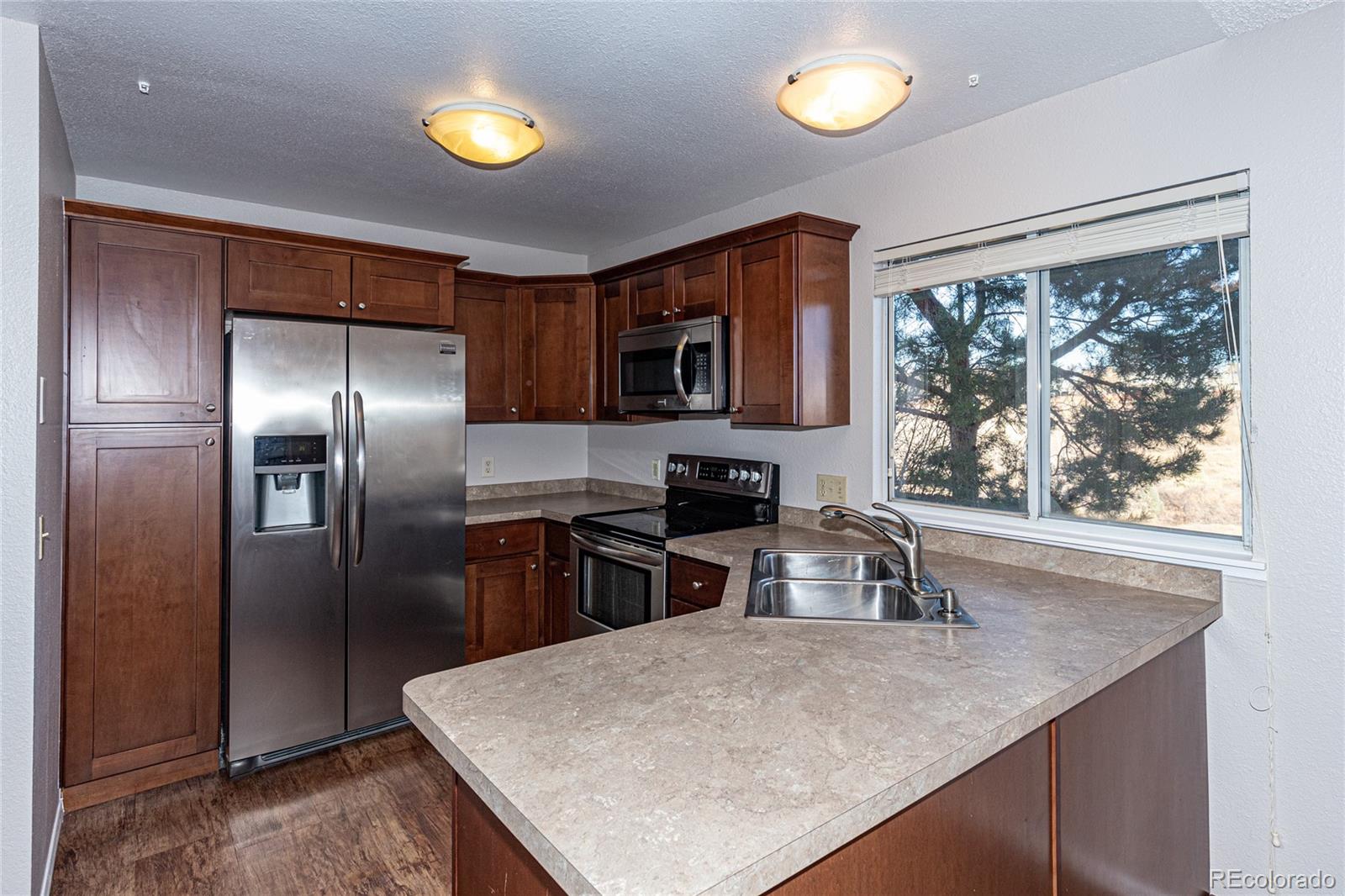 9498 Pendleton Drive Highlands Ranch, CO 80126 - Photo 13 of 28 a kitchen with a center island and a window