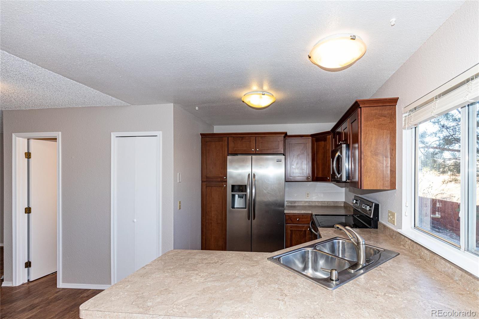 9498 Pendleton Drive Highlands Ranch, CO 80126 - Photo 14 of 28 a kitchen with a refrigerator and a sink