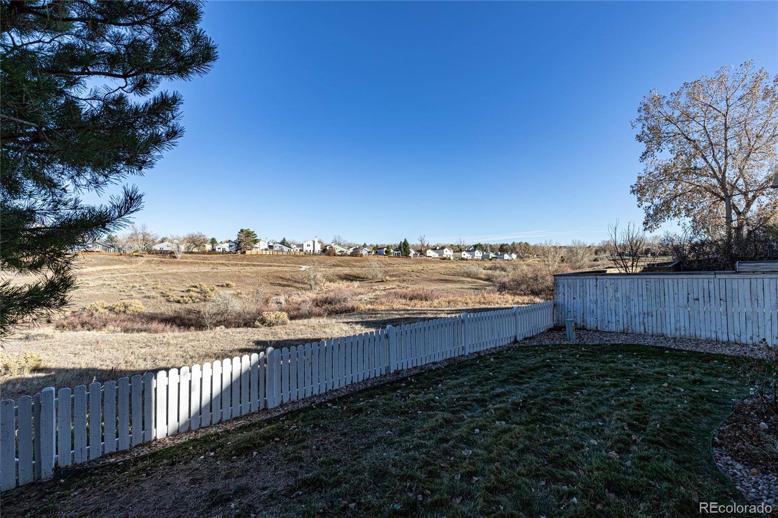 9498 Pendleton Drive Highlands Ranch, CO 80126 - Photo 26 of 28 a view of a yard next to a yard with a lake view