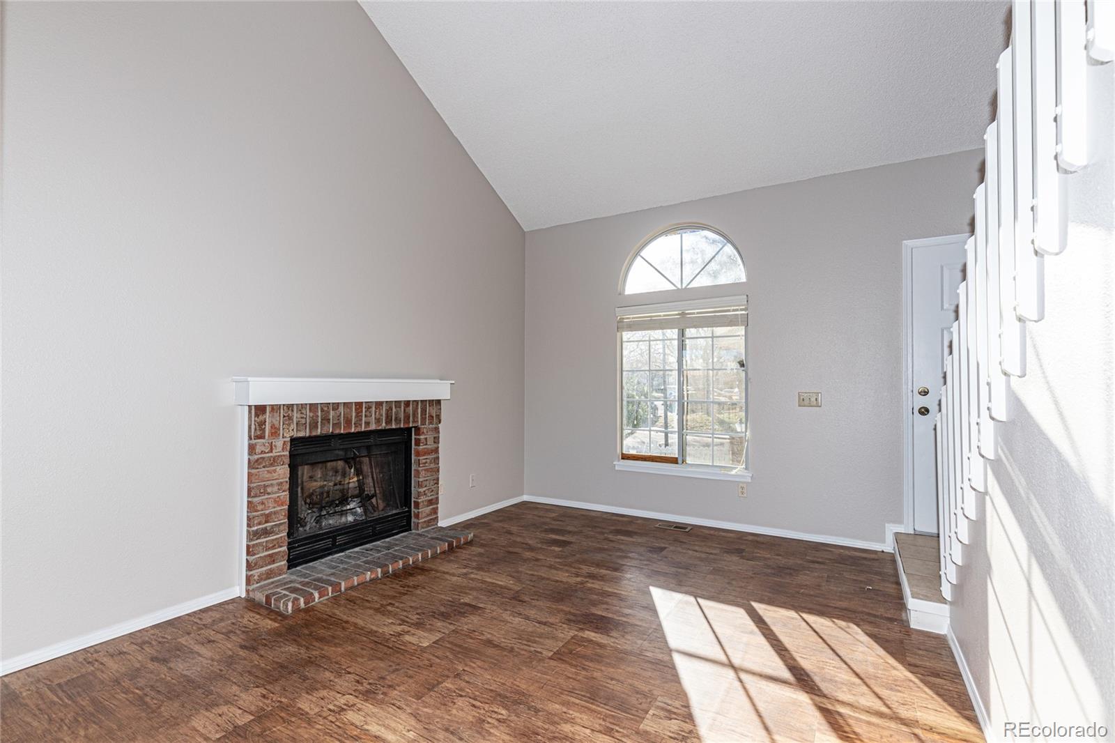 9498 Pendleton Drive Highlands Ranch, CO 80126 - Photo 5 of 28 an empty room with a fireplace and windows
