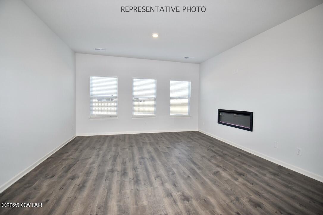 39 Kings Gate Cove Jackson, TN 38305 - Photo 7 of 19 an empty room with wooden floor and windows