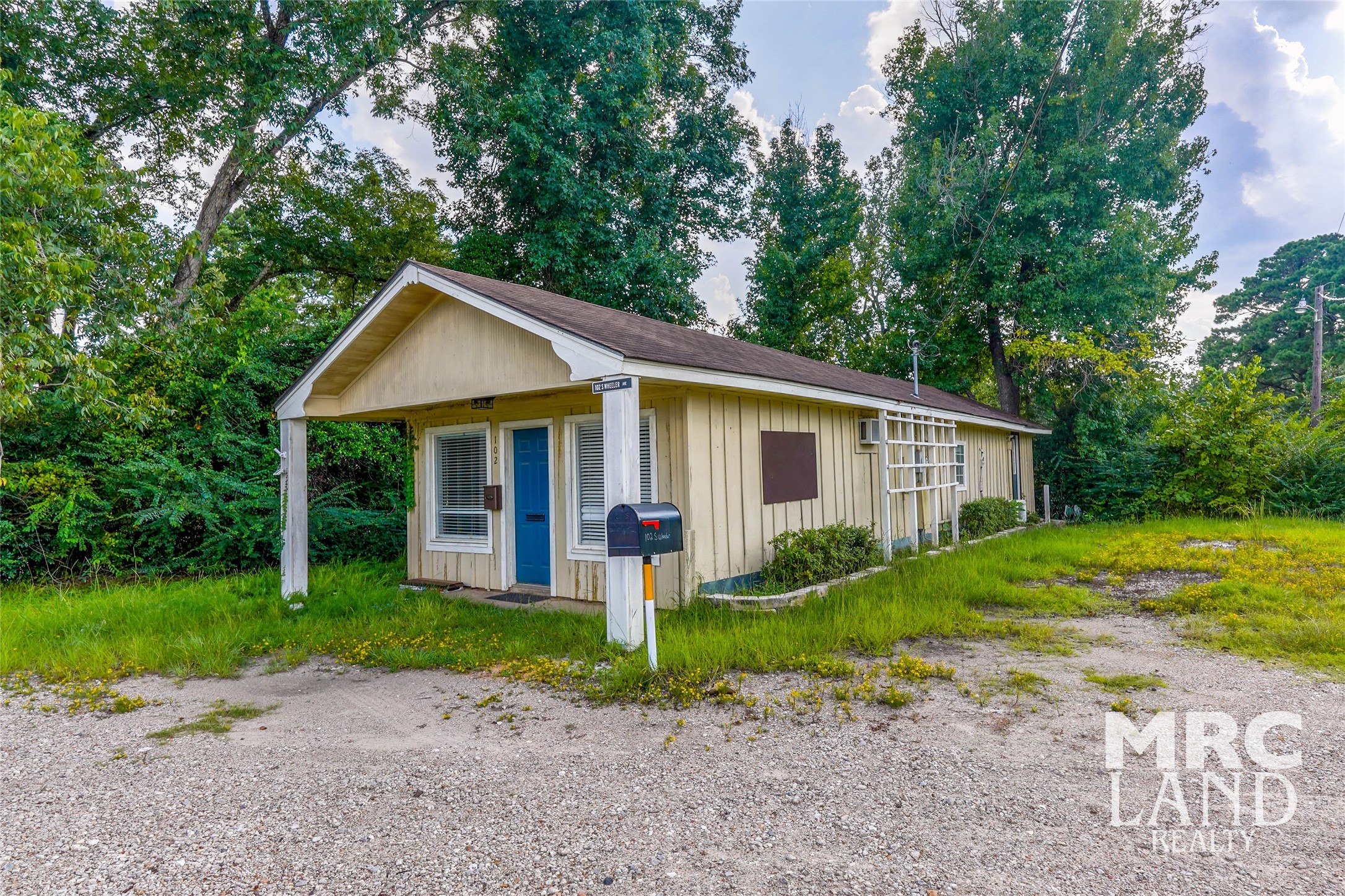 102 South Wheeler Avenue Colmesneil, TX 75938 - Photo 1 of 17 a view of a yard in front of a house with large trees