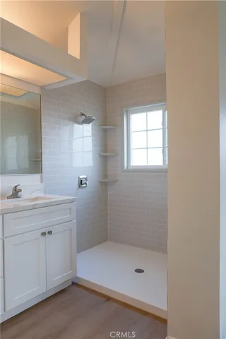 a bathroom with a shower a sink and a mirror