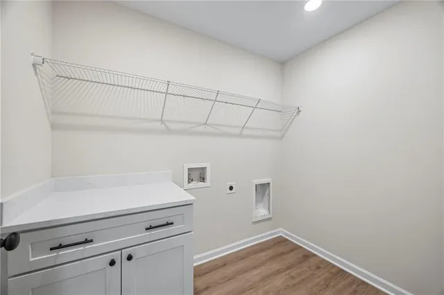 a view of a kitchen with white cabinets and wooden floor