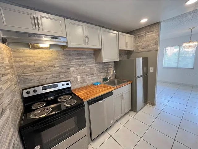 a kitchen with stainless steel appliances granite countertop a stove a refrigerator and a cabinets