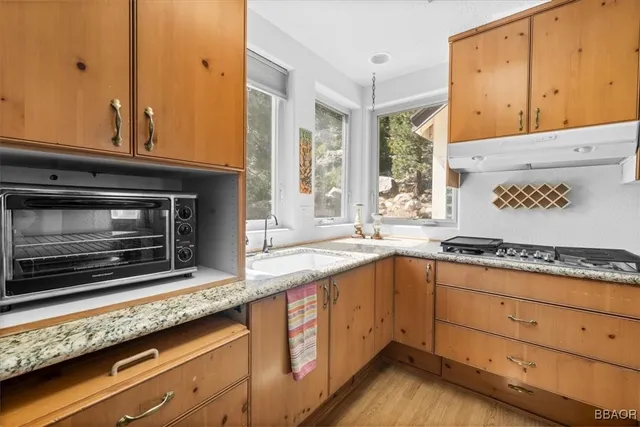 a kitchen with granite countertop cabinets stainless steel appliances and a counter space