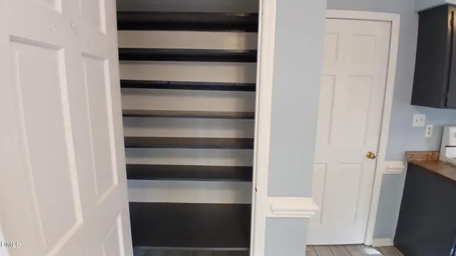 a view of walk in closet with empty racks
