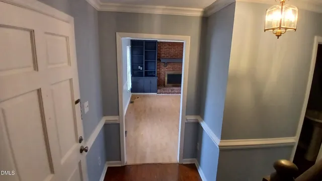 a view of a hallway with wooden floor and staircase