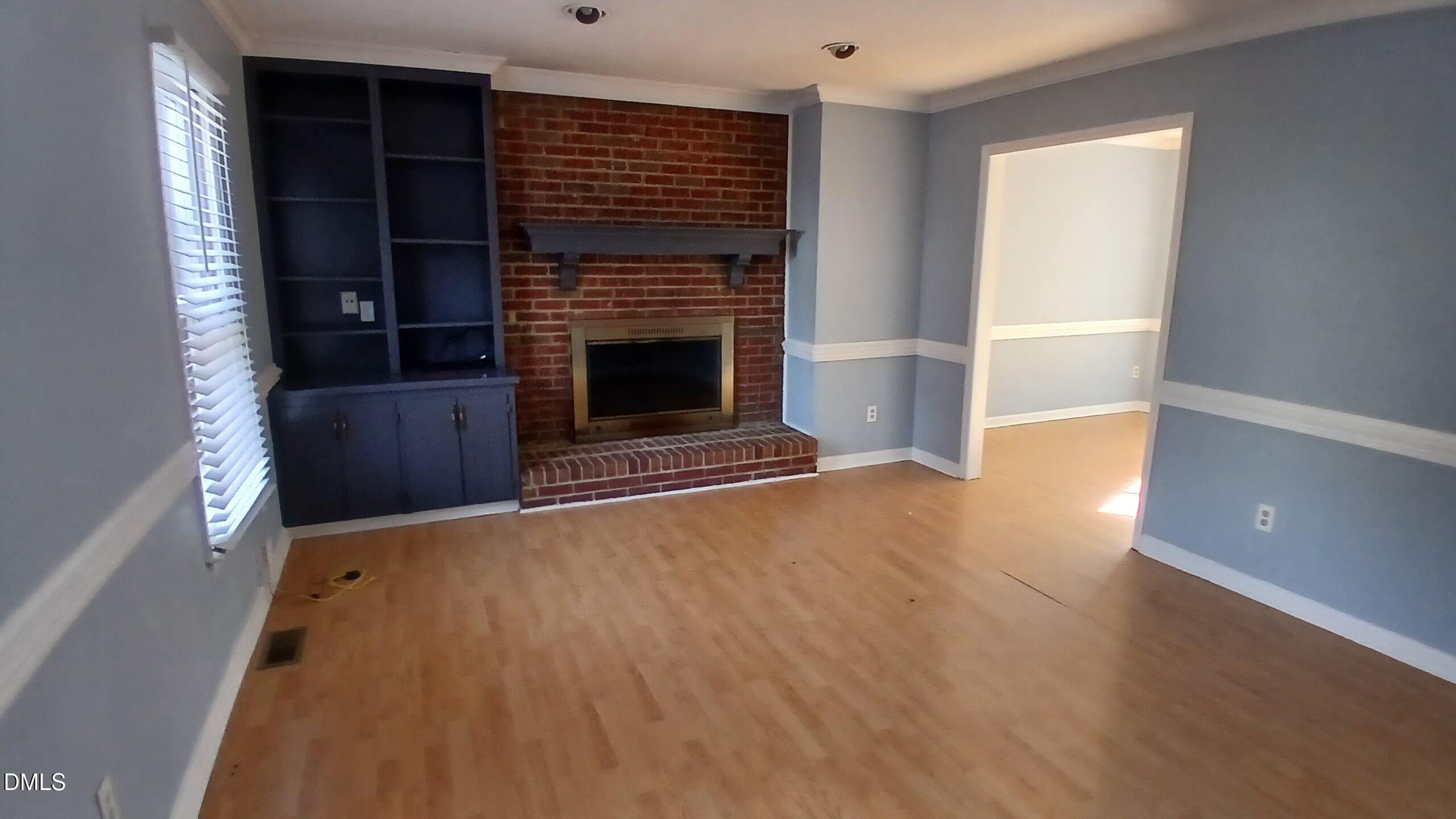 3504 East Jameson Road Raleigh, NC 27604 - Photo 6 of 35 a view of an empty room with wooden floor fireplace and a window