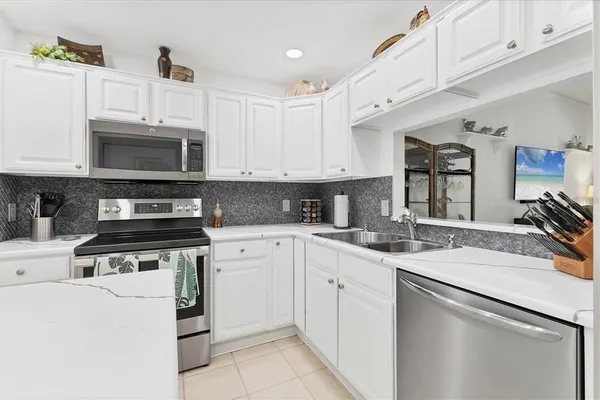 a large white kitchen with cabinets