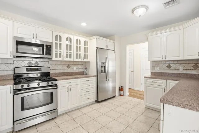 a kitchen with granite countertop cabinets stainless steel appliances and a counter space