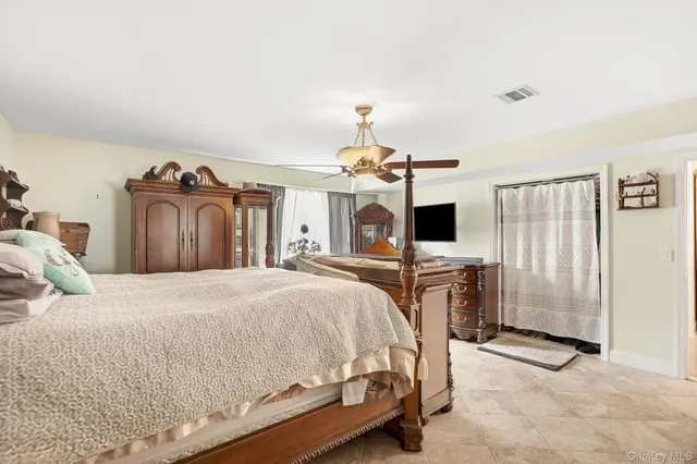 a bedroom with a large bed and a tv