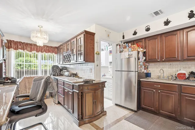 a kitchen with stainless steel appliances granite countertop a stove a refrigerator a sink dishwasher a dining table and chairs with wooden floor