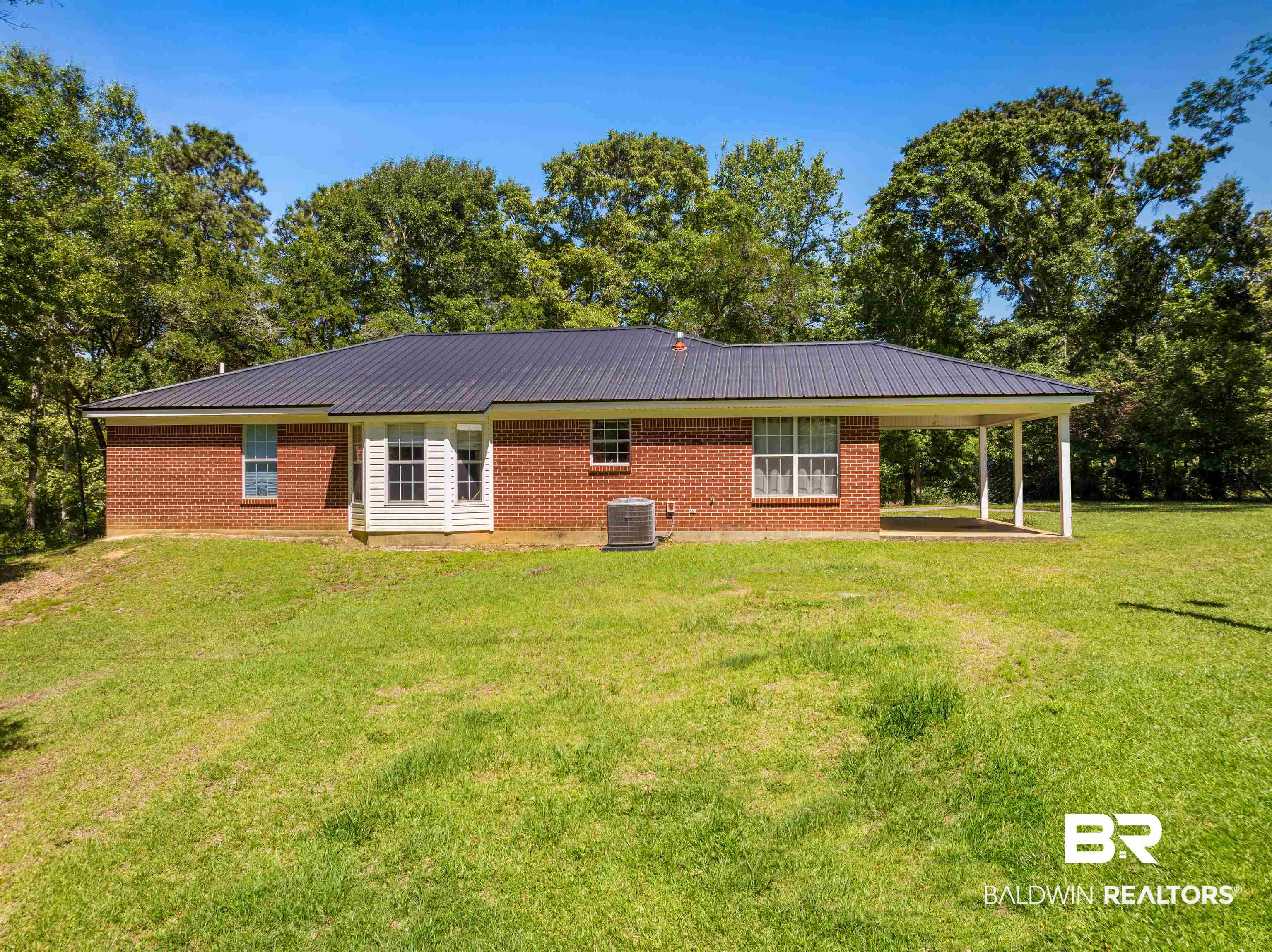 35893 Pine Road South Stapleton, AL 36578 - Photo 6 of 31 Brick exterior with a dark metal roof and a covered patio