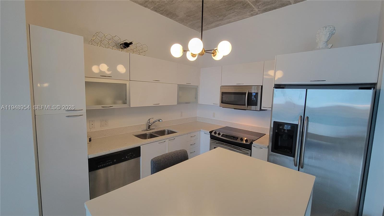 234 Northeast 3rd Street, Unit 1209 Miami, FL 33132 - Photo 3 of 12 a kitchen with a refrigerator a microwave a stove and cabinets