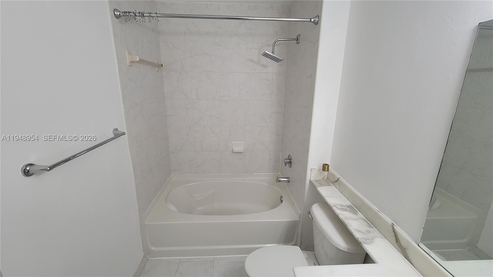 234 Northeast 3rd Street, Unit 1209 Miami, FL 33132 - Photo 6 of 12 a white bath tub sitting next to a white toilet and vanity
