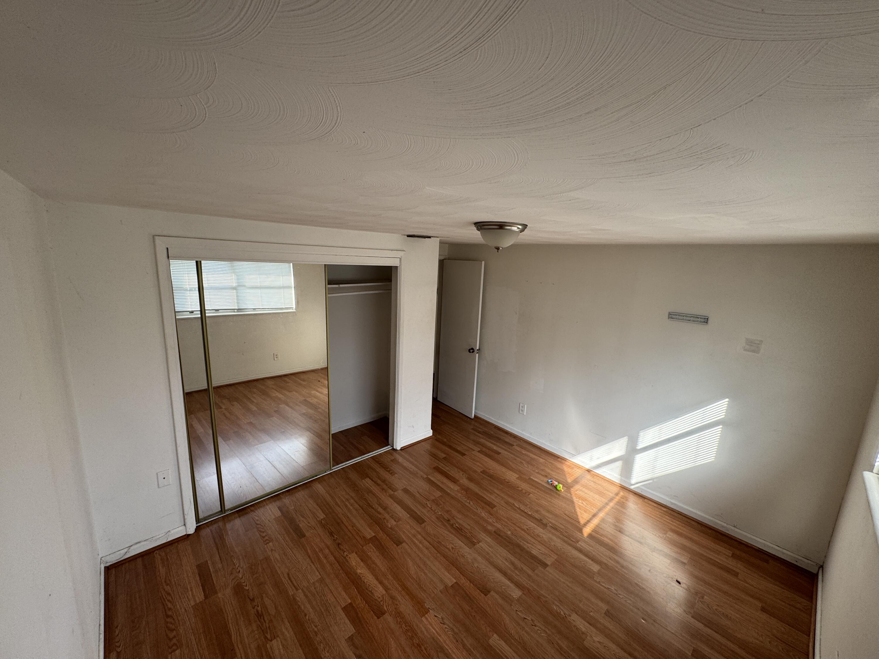 5645 Papaya Road Royal Palm Estates, FL 33413 - Photo 11 of 23 an empty room with wooden floor and closet