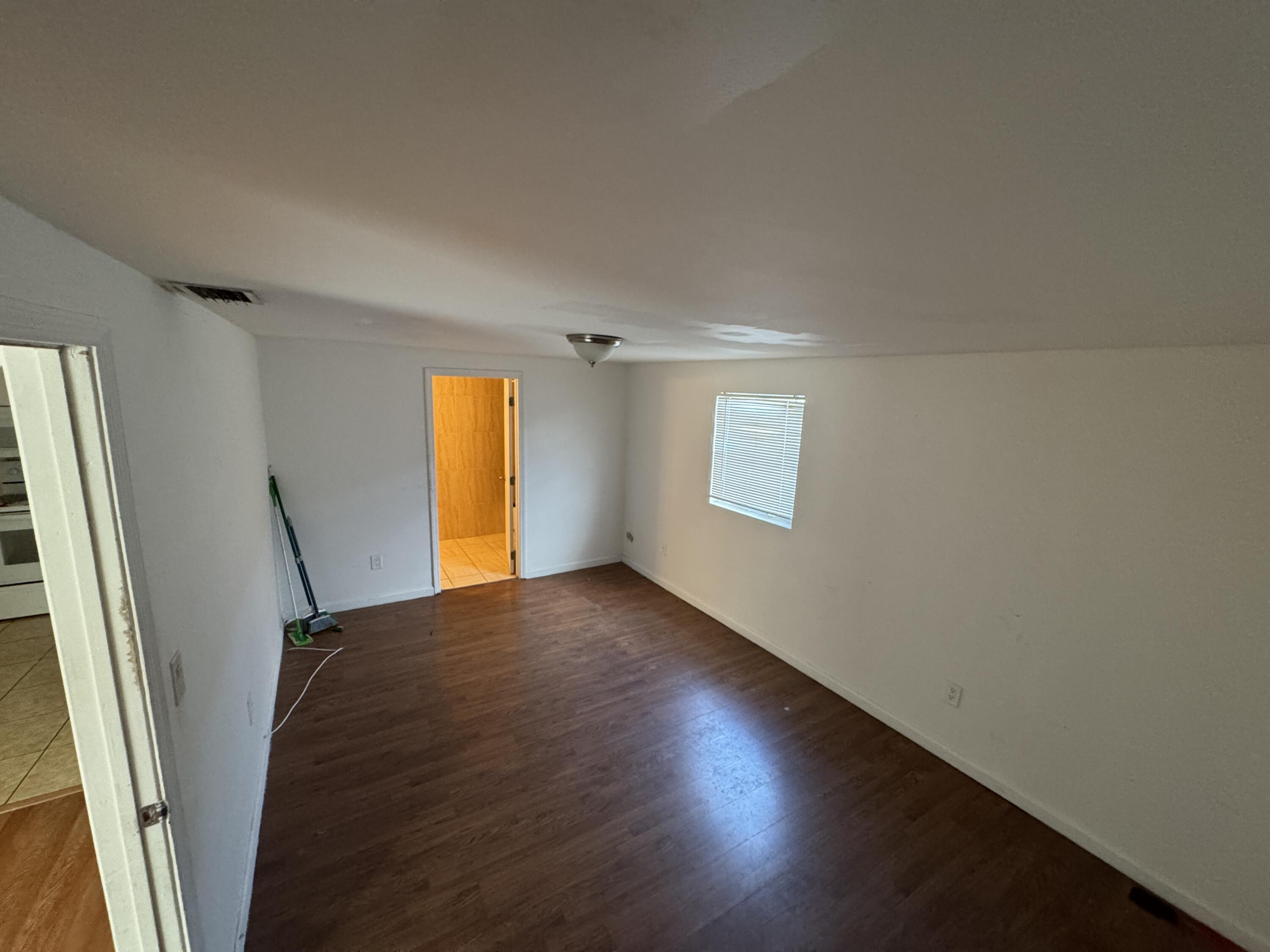 5645 Papaya Road Royal Palm Estates, FL 33413 - Photo 12 of 23 a view of empty room with window and wooden floor
