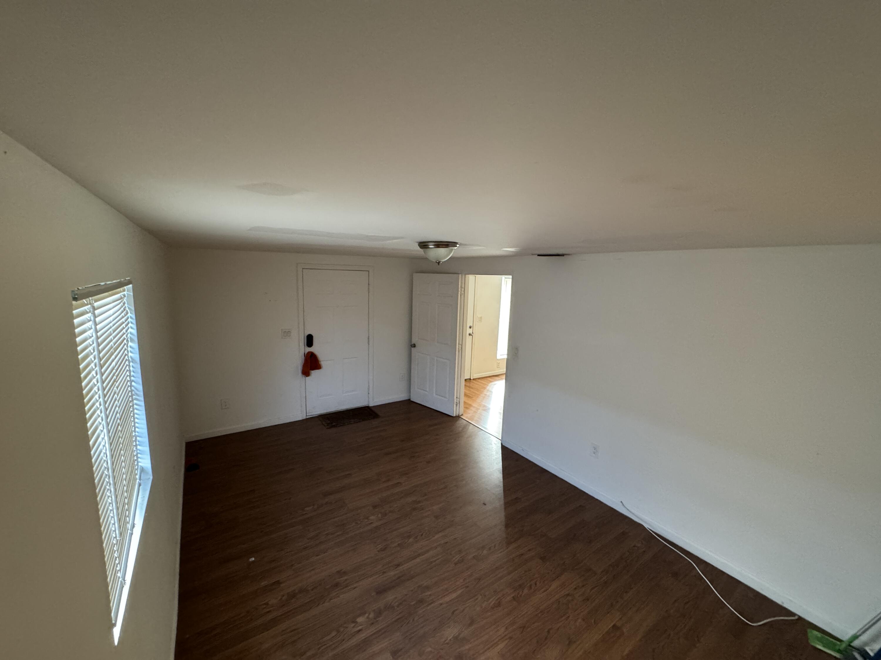 5645 Papaya Road Royal Palm Estates, FL 33413 - Photo 13 of 23 an empty room with wooden floor and windows