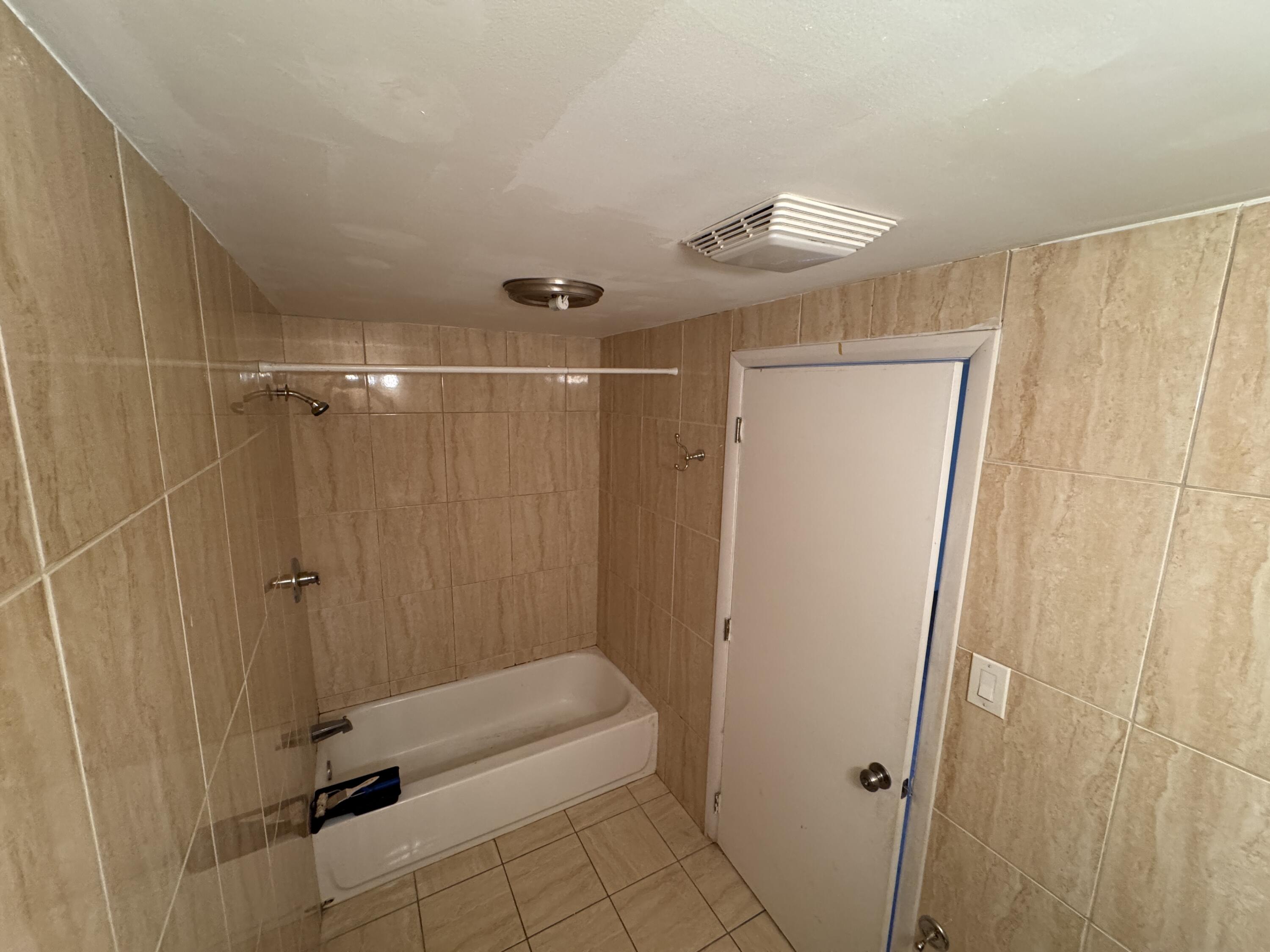 5645 Papaya Road Royal Palm Estates, FL 33413 - Photo 14 of 23 a bathroom with a shower and a tub