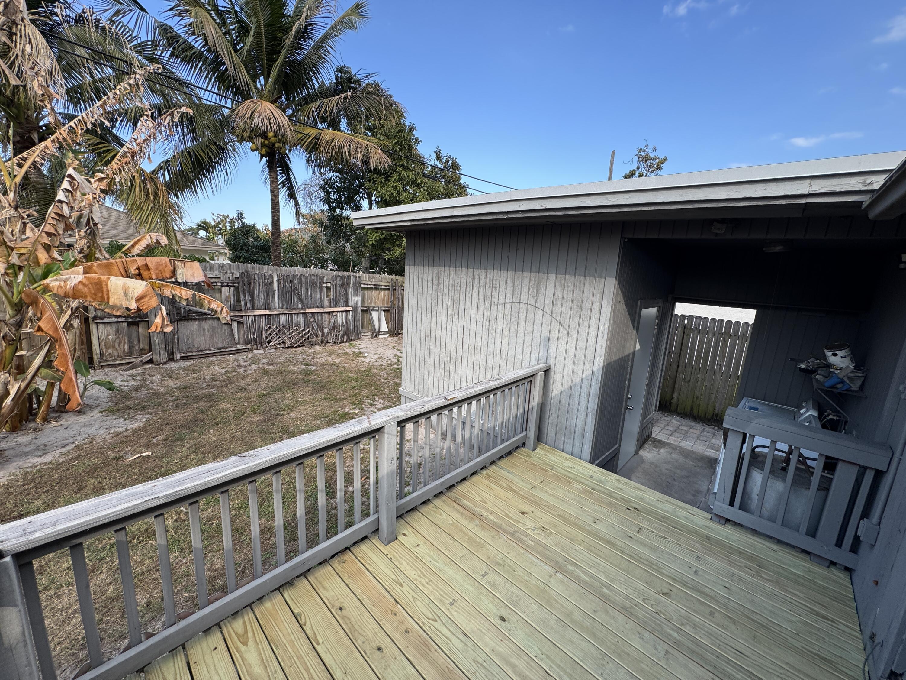 5645 Papaya Road Royal Palm Estates, FL 33413 - Photo 18 of 23 a view of a roof deck with table and chairs with wooden floor and fence