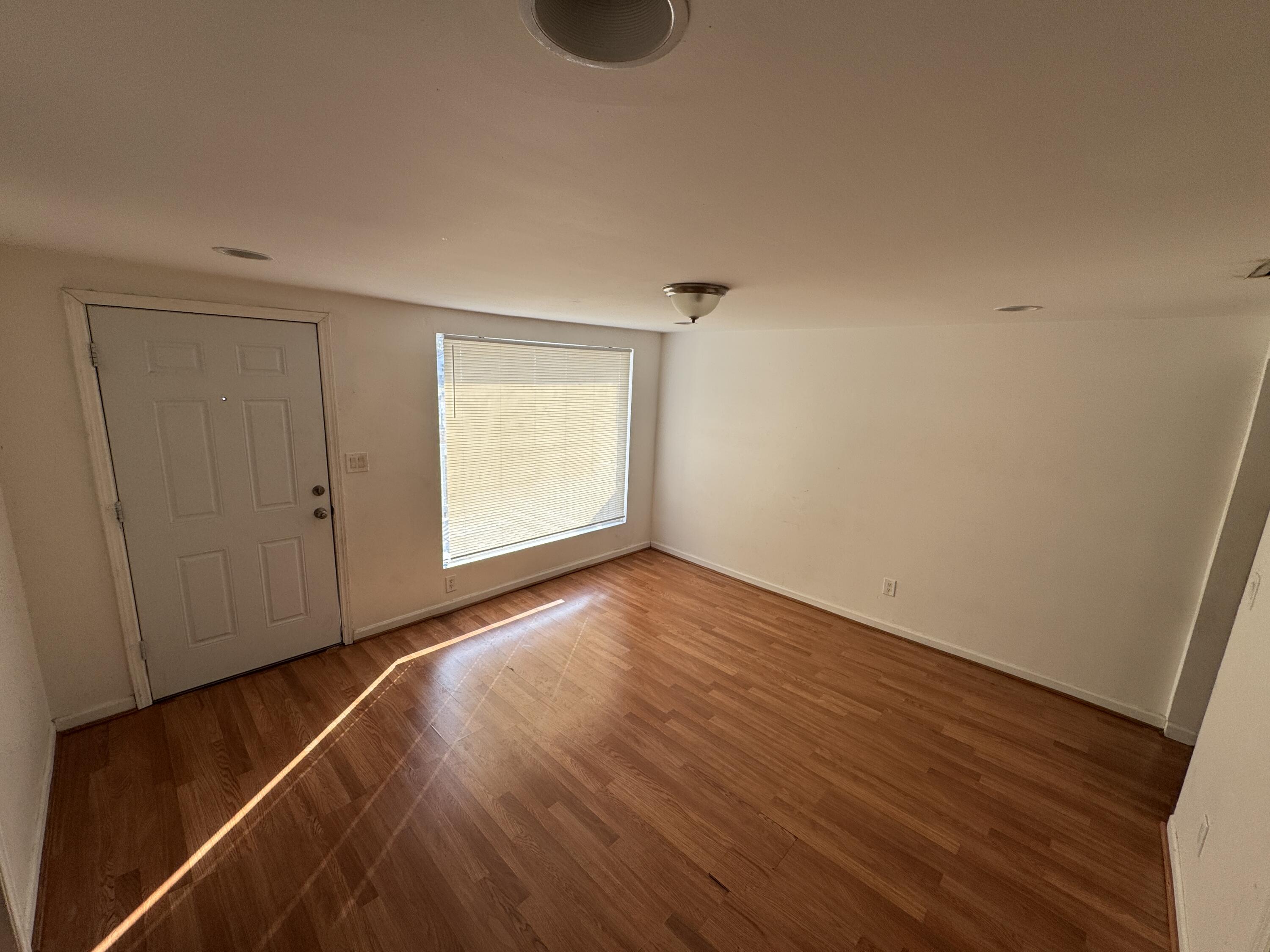 5645 Papaya Road Royal Palm Estates, FL 33413 - Photo 3 of 23 a view of an empty room with wooden floor and a window