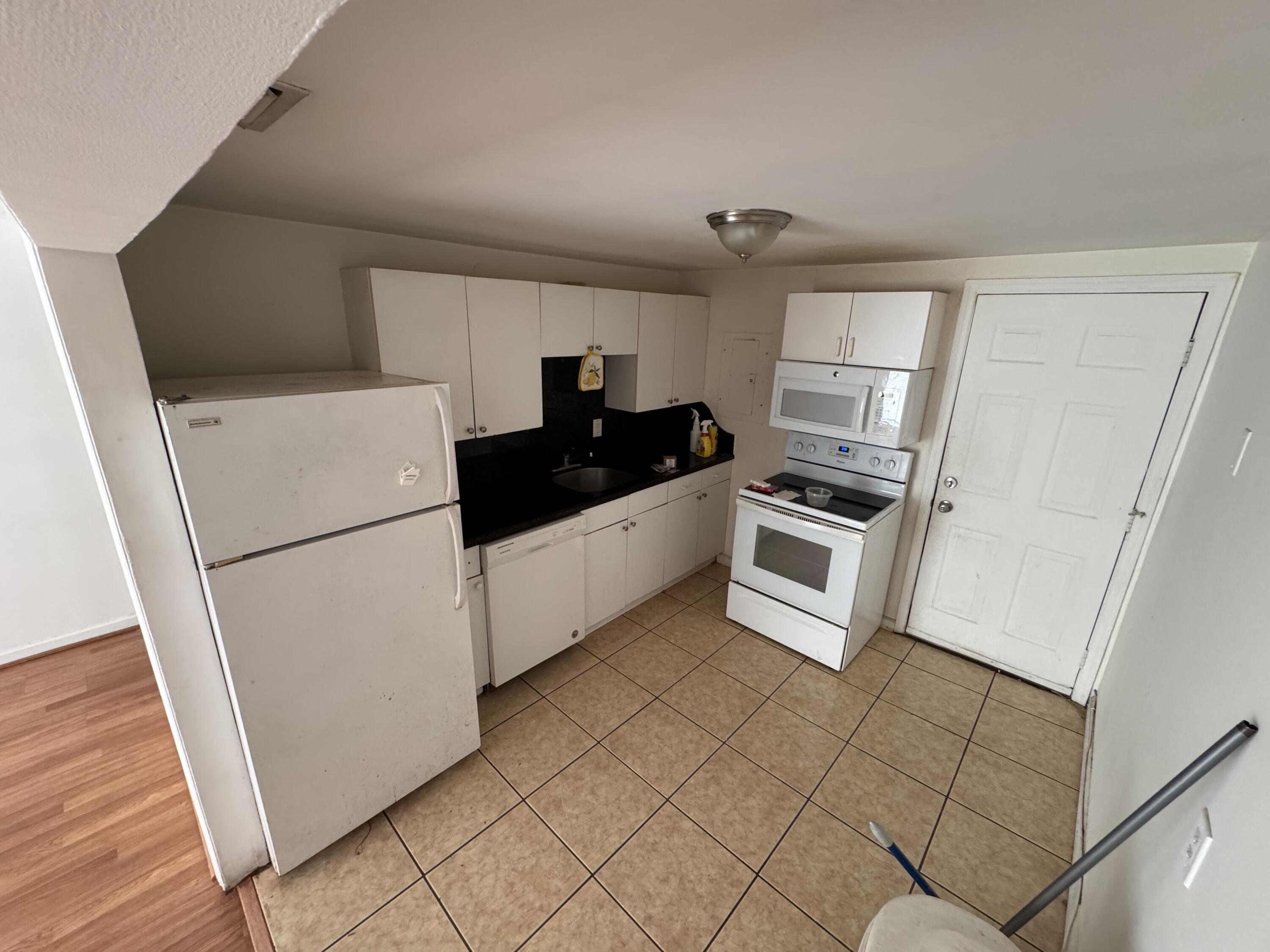 5645 Papaya Road Royal Palm Estates, FL 33413 - Photo 4 of 23 a kitchen with granite countertop white cabinets and white appliances