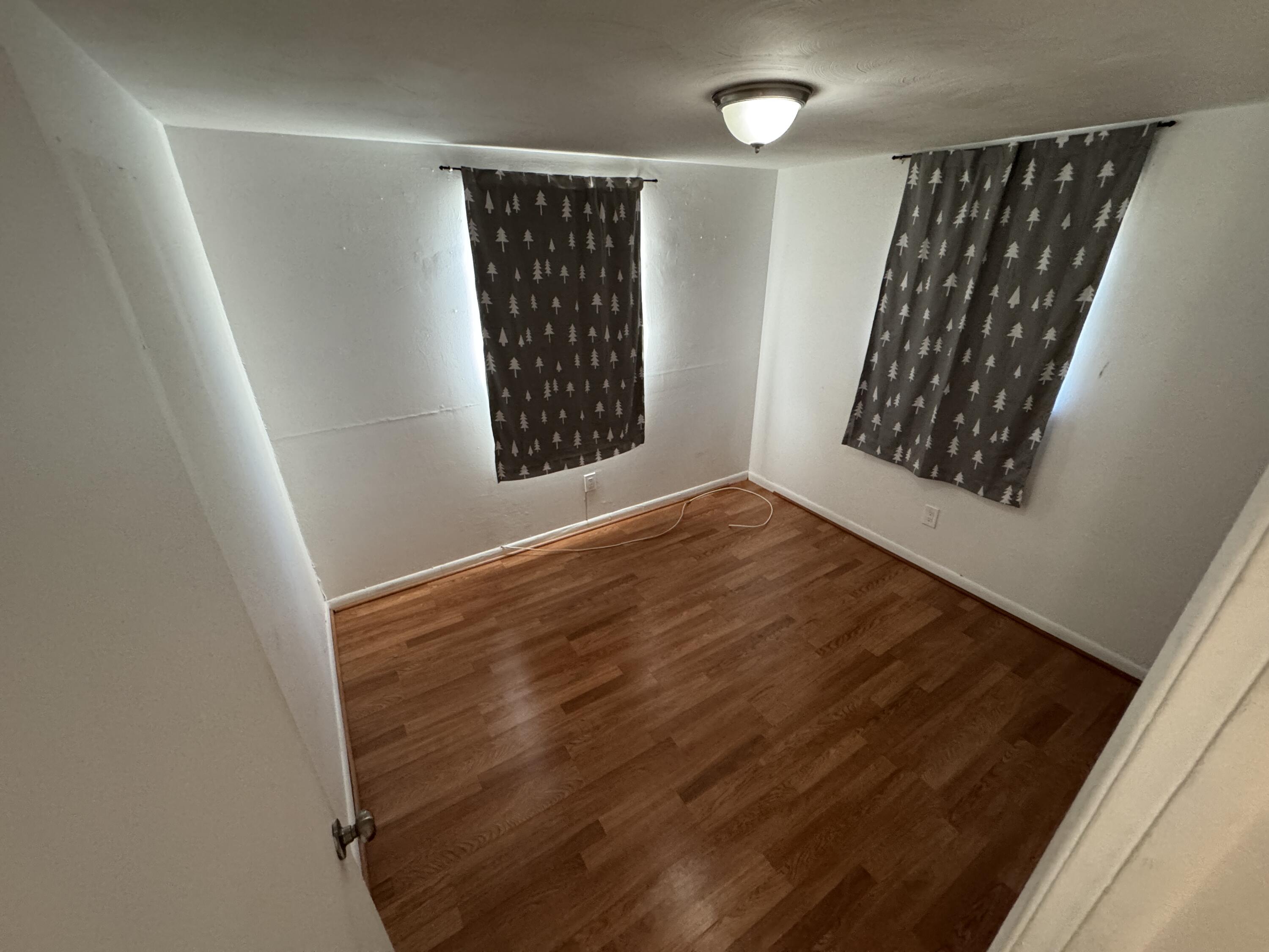 5645 Papaya Road Royal Palm Estates, FL 33413 - Photo 8 of 23 view of wooden floor with windows in an empty room