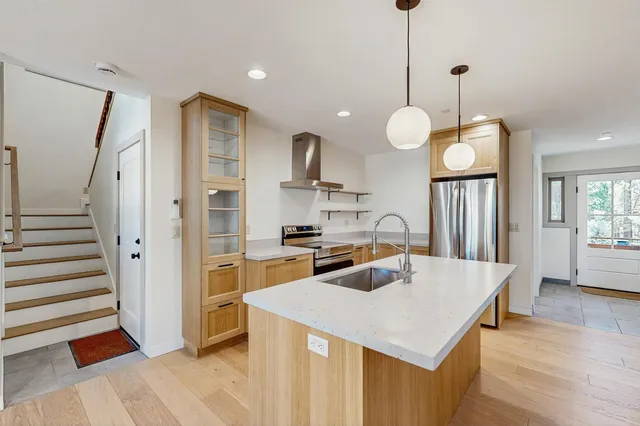 a kitchen that has a lot of cabinets and a wooden floor