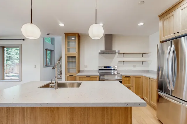 a kitchen with stainless steel appliances granite countertop a sink a stove and a refrigerator