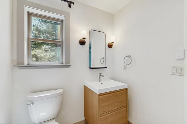 a bathroom with a toilet sink and mirror