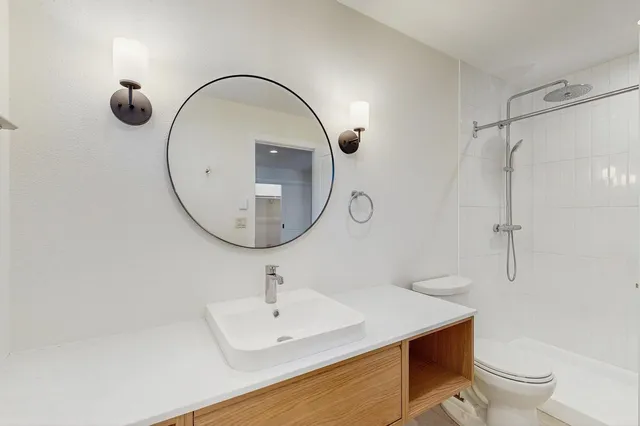 a bathroom with a sink a toilet and a mirror