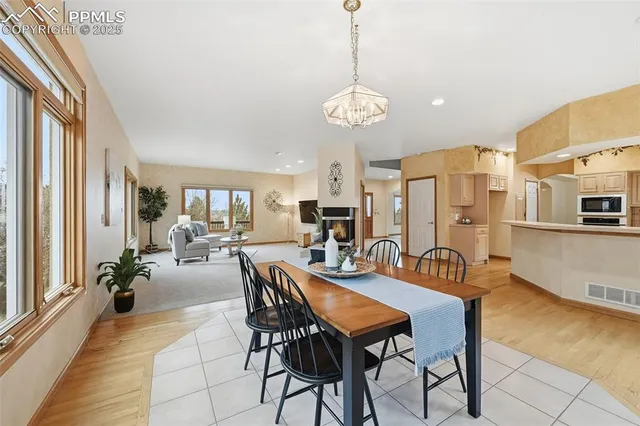 a view of a dining room and livingroom with furniture wooden floor a chandelier