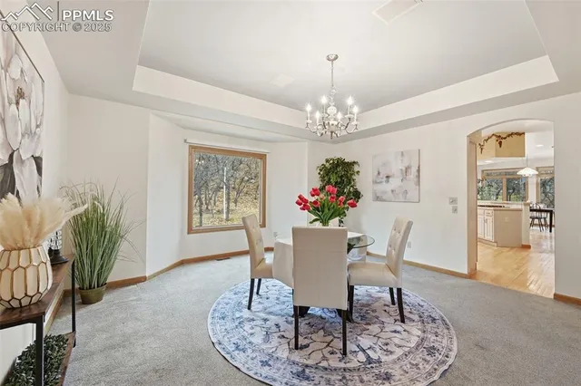 a view of a dining room with furniture and a chandelier
