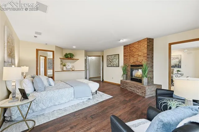 a spacious bedroom with a bed a couch and fireplace