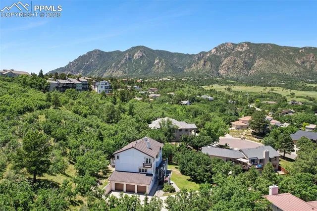 a view of a big house with a big yard and large trees