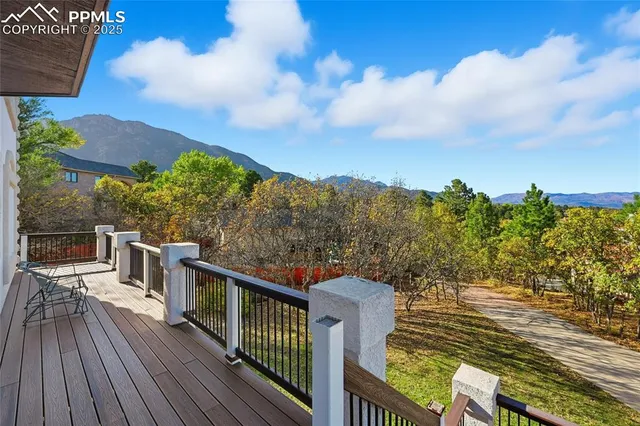 a view of a balcony with wooden floor and fence with a bench