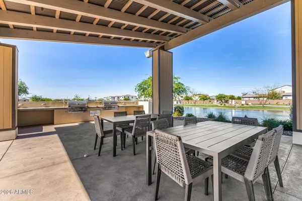 a view of swimming pool with outdoor seating and trees in the background