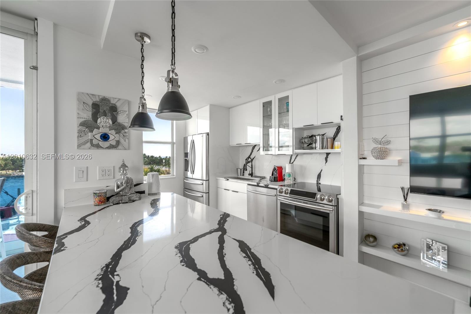 2639 North Riverside Drive, Unit 501 Pompano Beach, FL 33062 - Photo 2 of 39 a kitchen with stainless steel appliances kitchen island granite countertop a stove a sink dishwasher and white cabinets with wooden floor