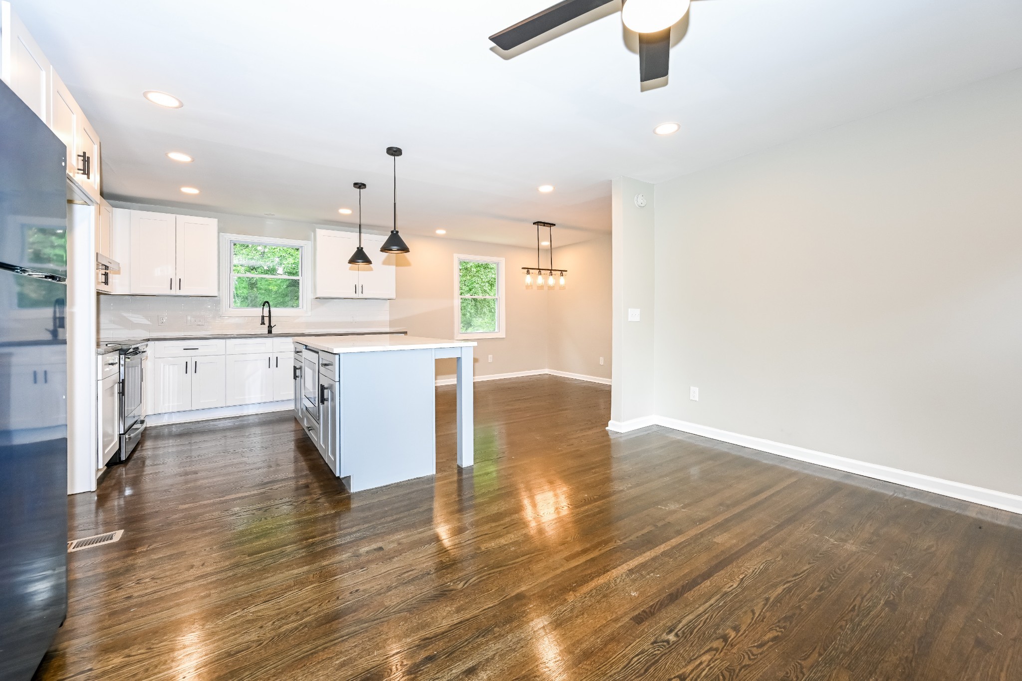 4932 Aquatic Road Nashville, TN 37211 - Photo 3 of 16 a kitchen with stainless steel appliances granite countertop a stove top oven a sink dishwasher and white cabinets with wooden floor