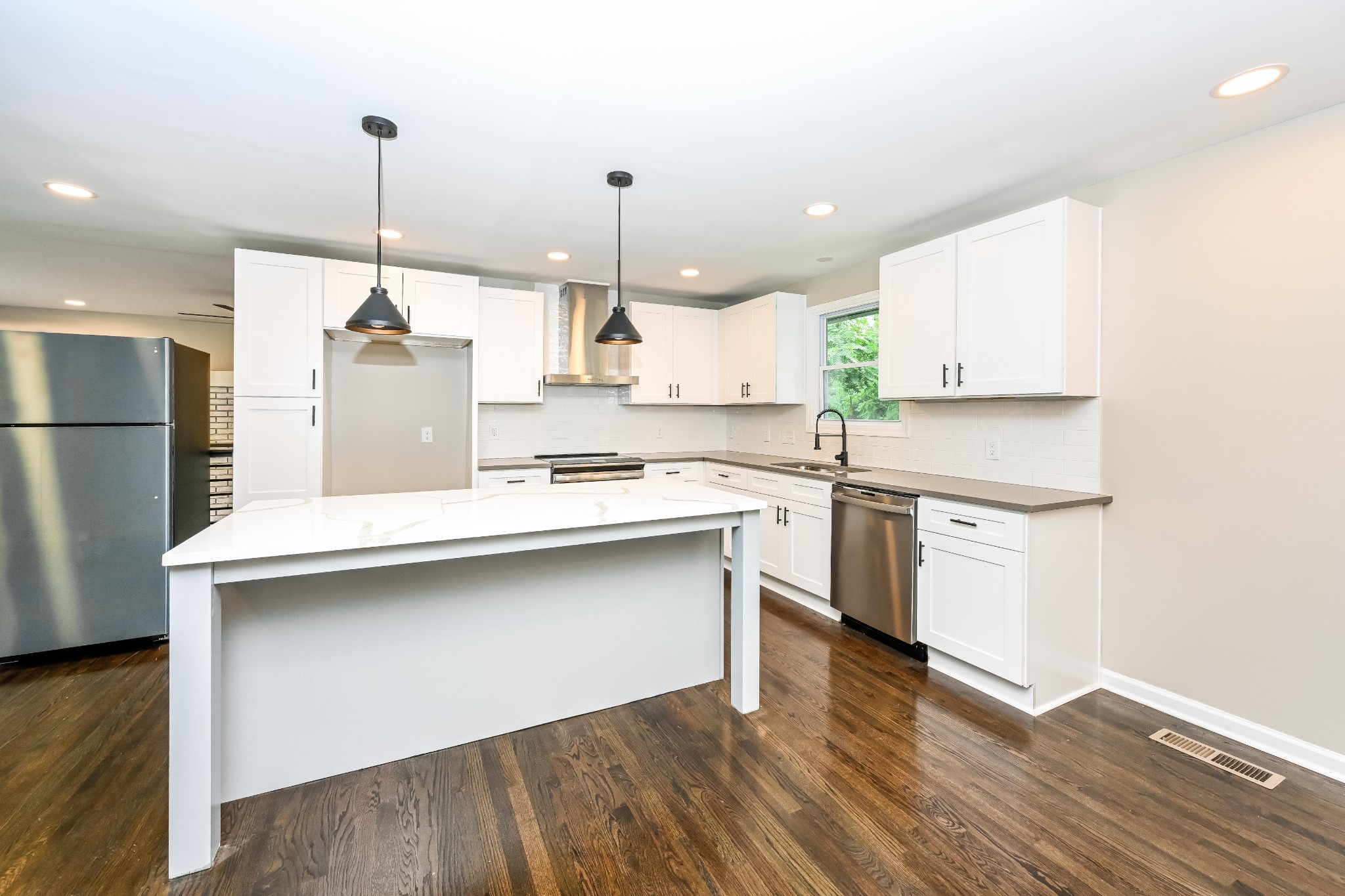 4932 Aquatic Road Nashville, TN 37211 - Photo 7 of 16 a kitchen with stainless steel appliances granite countertop a sink a stove a refrigerator and island with wooden floor